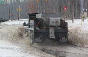 A truck drives though a puddle of water on Tide Road in Hometown.