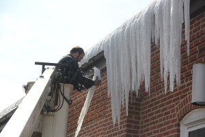 Dave Lesniak, Tamaqua borough mechanic, uses a bucket lift to remove ice from the side of the borough hall.
