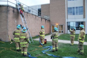 Firefighter Robert Amentler uses rope to lift items up the ladder during a recent training exercise.