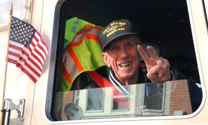 Steve Daderko, Navy veteran, gives the peace sign as he sits in the passenger seat of an American Hose Company fire truck during the 2011 Tamaqua Veteran's Day Parade. Daderko served in World War II on the USS Navaro.