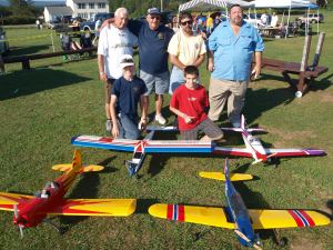 TAMAQUAAREA.COM FILE PHOTO/Pictured in 2010 with a few RC aircraft during the Tuscarora RC Club's 19th Annual Aerorama held recently at their Tuscarora State Park flying field are kneeling, from left, Tuscarora RC Flying Club (T.R.C.F.C.) member Cullen Dixon, 13, and Julian Huegel, 13. Standing, from left, are T.R.C.F.C. members Gordon Biehl, his mentor and past President George Moyer, Randy Grude, and President William Huegel.
