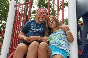 Painted as tigers, Sheridan Downing, 11, and Cierra Conahan, 11, sit atop a jungle gym during the event. 