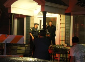 Tamaqua Police officers Tom Rodgers, left, and Keith Krapf help firefighters take the door off the hinges. Rodgers used a fire extinguisher to quell the stove fire.