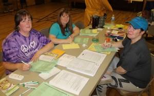 Pictured from left are co-community leaders Tara Goho, Nancy Paisley, and Linda Kasza (who is registering her 12 year old daughter).