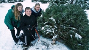 Posing next to their freshly cut Christmas tree are siblings, from left, Casey, Cody and Carley Sassaman.