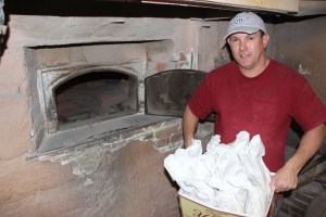 Pictured is Larry Padora distributing free bread in exchange for a donation of a new toy.