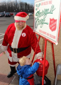 Abraham Greenly places a donation in the bucket.