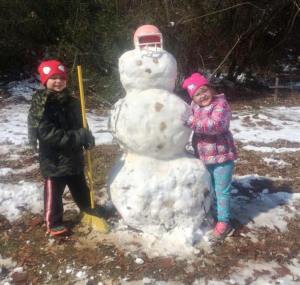 Wyatt, 7, and Suzie, 6, stand next to their snowman creation.