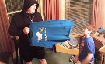 Adam Green, 9, looks in amazement as his dad, Matt, holds up the frozen t-shirt.