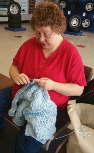 Joan Gibbons works on a blanket in the waiting area of Firestone Tire and Automotive in Hazleton.
