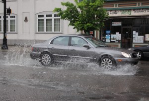 A driver travels through a pothole at the intersection of Hunter and West Broad Street this evening.