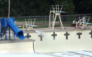 A large hose shoots clean water into the deep section of Tamaqua's Bungalow Pool a day after the pool was filled with dirty rain runoff after flash flooding.