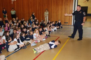 Program coordinator Chris Hadesty (firefighter and paramedic) teaches Russell Parker, age 7, of Mrs. Jones class how to stop, drop and roll.