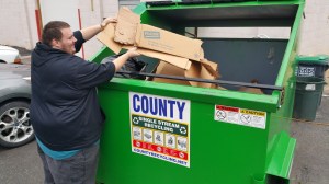 Pictured is Frank Latham placing flattened cardboard in the dumpster.
